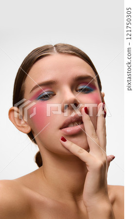 Portrait of beautiful young woman with bold colors, strong blush accents, and striking poses, shows individuality, against white studio background. Concept of natural beauty. Portrait of beautiful young woman with bold colors, strong blush accents, and striking poses, shows individuality, against white studio background. Concept of natural beauty. 121750305