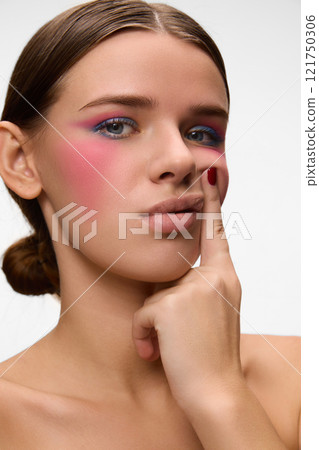 Focused on vibrant makeup, woman's soft gaze blends elegance and artistic exploration of modern beauty techniques against white background. Focused on vibrant makeup, woman's soft gaze blends elegance and artistic exploration of modern beauty techniques against white background. 121750306