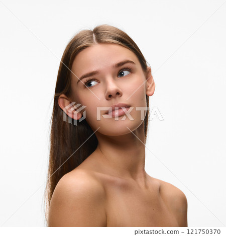 Portrait of young attractive woman looking away show her perfect smooth skin against white studio background. Concept of natural beauty. Portrait of young attractive woman looking away show her perfect smooth skin against white studio background. Concept of natural beauty. 121750370