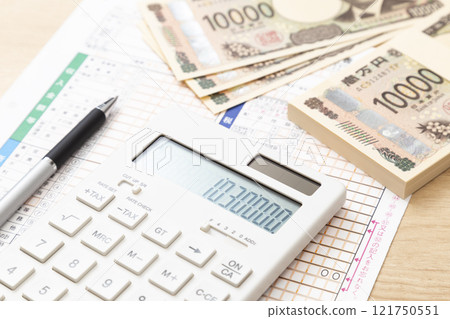 Tax return documents and a calculator on a desk 121750551