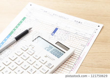 Tax return documents and a calculator on a desk 121750629