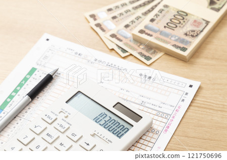 Tax return documents and a calculator on a desk 121750696