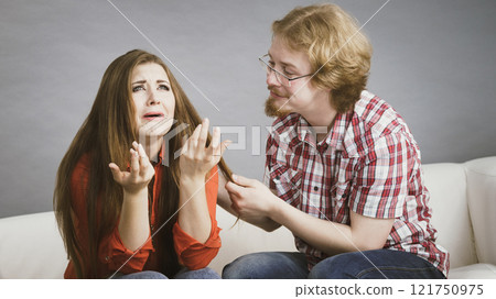Woman confiding to man on sofa Woman confiding to man on sofa 121750975