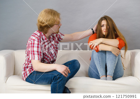 Woman confiding to man on sofa Woman confiding to man on sofa 121750991