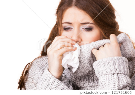 Sick freezing woman sneezing in tissue 121751605