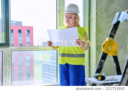 Technical profession woman in protective vest helmet working on construction Technical profession woman in protective vest helmet working on construction 121751691