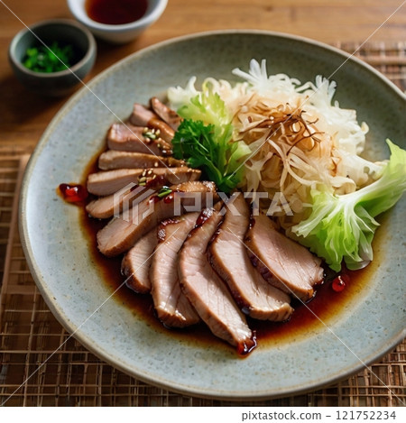 Slices of glazed pork with salad on a ceramic plate.  121752234