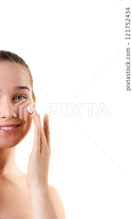 Collage. Smiling young woman applying cream to her cheek against white studio background, symbolizing freshness and joy in daily beauty care. Collage. Smiling young woman applying cream to her cheek against white studio background, symbolizing freshness and joy in daily beauty care. 121752434