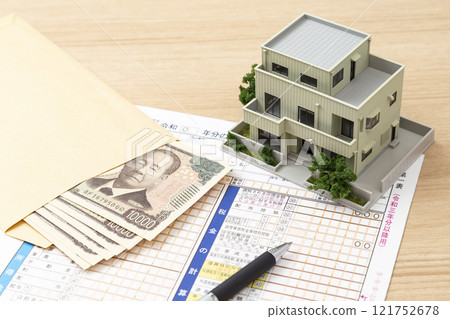 Tax return documents and a model house on a desk Tax return documents and a model house on a desk 121752678