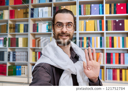 Selfie photo portrait young 30s positive man in glasses inside library 121752784