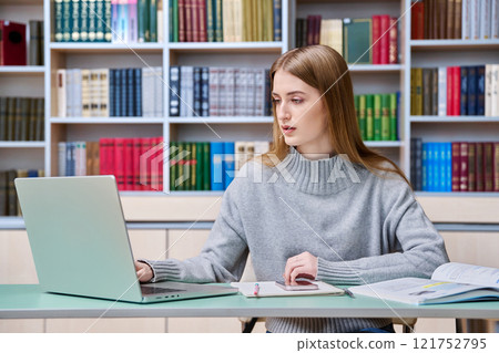 Teenage girl student studying in high school library Teenage girl student studying in high school library 121752795