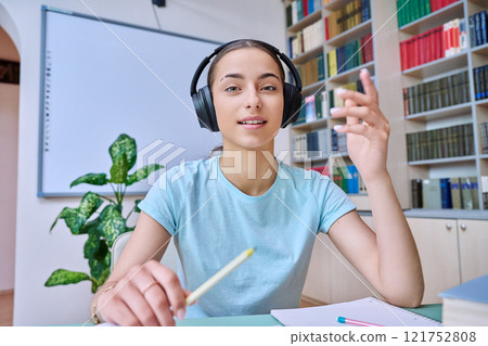 Webcam view of teenage girl, high school student, in headphones, talking to camera Webcam view of teenage girl, high school student, in headphones, talking to camera 121752808