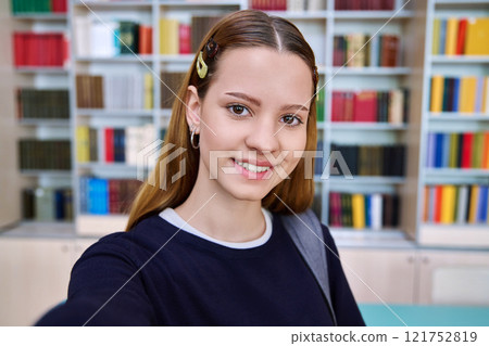 Selfie portrait of happy cheerful high school student girl, inside library Selfie portrait of happy cheerful high school student girl, inside library 121752819
