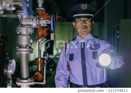 夜間拿著手電筒守衛大樓的男性保全攝影提供:東京電子學院登波學園教育法人。 夜間拿著手電筒守衛大樓的男性保全攝影提供:東京電子學院登波學園教育法人。 121754811