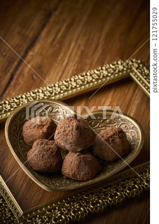 Chocolate truffles served in a heart-shaped container 121755029