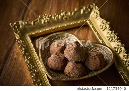 Chocolate truffles served in a heart-shaped container Chocolate truffles served in a heart-shaped container 121755040