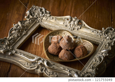 Chocolate truffles served in a heart-shaped container 121755049