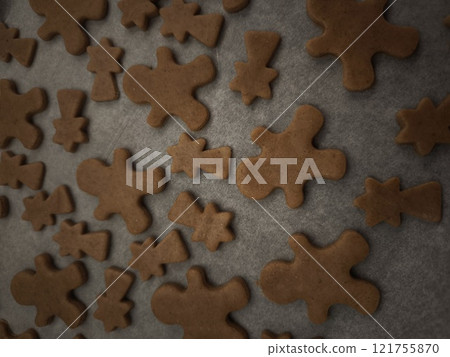 Gingerbread men and comets cookies baking on a tray and paper, ready for the holiday season christmas 121755870