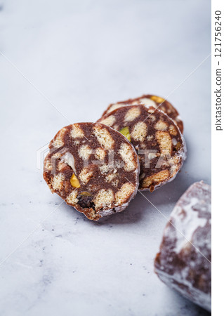 Chocolate salami with nuts on white background. Traditional Italian sweet sausage for Easter. 121756240