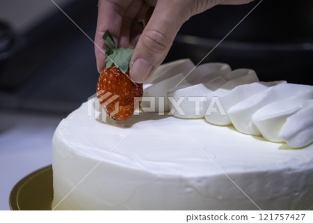 Strawberry arrangement on decorated cake 121757427