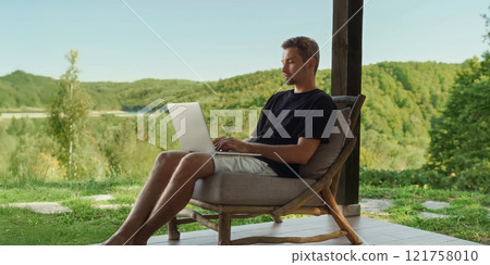 Freelancer works online on the terrace of a country house Freelancer works online on the terrace of a country house 121758010