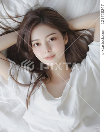 A cute Japanese woman lying on her back in bed 121758247