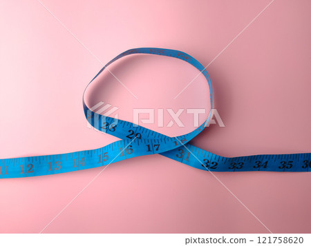 Top view blue measuring tape on a pink background. Medical and health concept. 121758620