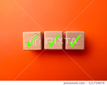 Green tick marking wooden cube for checklist in a row or to do list. 121758679