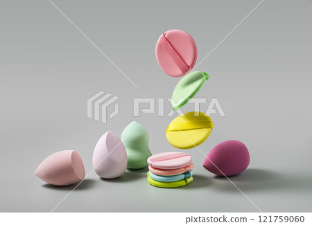 Vibrantly Colorful Makeup Sponges and Stylish Cosmetic Discs Resting on a Gray Background 121759060