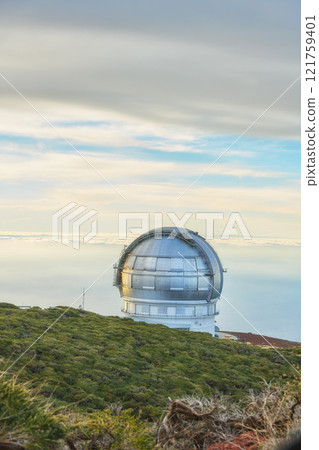 Scenic view of an astronomy observatory dome in Roque de los Muchachos, La Palma, Spain. Landscape of science infrastructure or building against blue sky with clouds and copyspace abroad or overseas 121759401