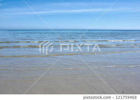 Small ocean waves on the shore against a clear blue sky with copy space. Landscape of the wide open sea or beach with calm water on a bright sunny day. Sea surface with ripples on the horizon Small ocean waves on the shore against a clear blue sky with copy space. Landscape of the wide open sea or beach with calm water on a bright sunny day. Sea surface with ripples on the horizon 121759468