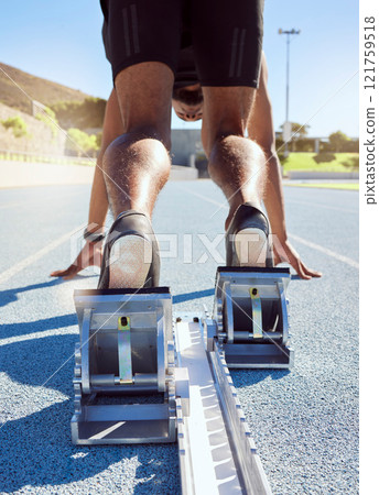 Feet of athlete in starting position on a running track. A male track and field runner ready to leave the starting block to start his sprint. Sportsman with hands on the starting line during a race 121759518
