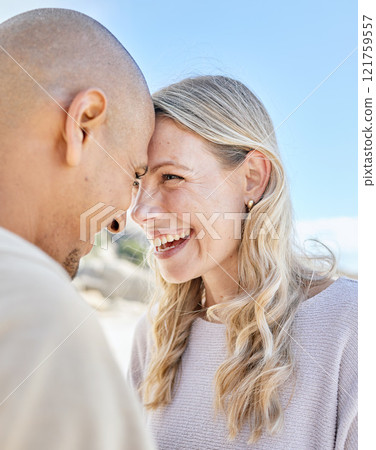 Intimate romantic couple bonding during a date. Mature loving interracial man and woman laughing and spending time together at the beach standing close to each other and smiling affectionately. Intimate romantic couple bonding during a date. Mature loving interracial man and woman laughing and spending time together at the beach standing close to each other and smiling affectionately. 121759557