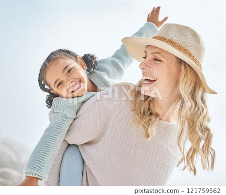 Portrait of a mother and daughter having fun and bonding on a beach vacation together. Happy adopted black child being playful and cute with her caucasian foster mom. Parent and kid enjoying summer Portrait of a mother and daughter having fun and bonding on a beach vacation together. Happy adopted black child being playful and cute with her caucasian foster mom. Parent and kid enjoying summer 121759562