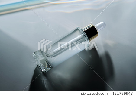 Bottle of face serum with a pipette with a beautiful highlight. Bottle of face serum with a pipette with a beautiful highlight. 121759948