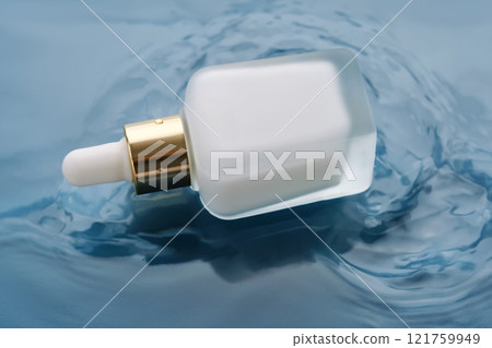 Bottle with white moisturizing serum in water on blue background. Bottle with white moisturizing serum in water on blue background. 121759949
