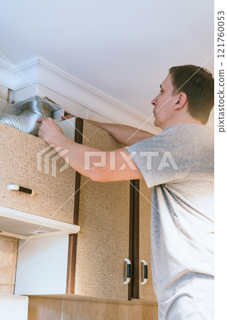 Man Fixing Kitchen Hood Man Fixing Kitchen Hood 121760053