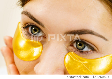 Woman with gold patches under eyes 121760894