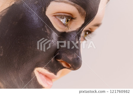 Woman with charcoal facial mask 121760982