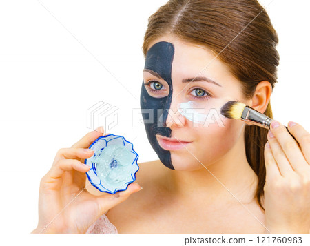 Girl black mask on half face apply white mud 121760983