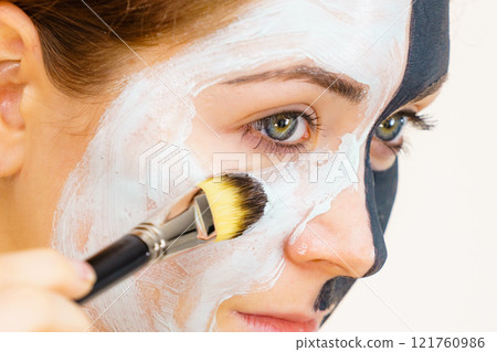 Girl black mask on half face apply white mud 121760986