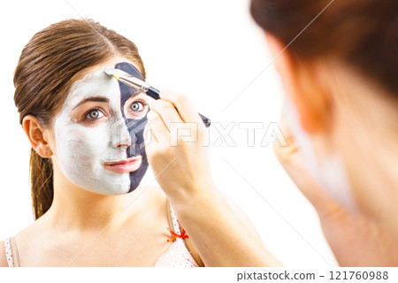Girl black and green mud mask on face 121760988