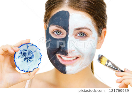 Girl black mask on half face apply white mud 121760989