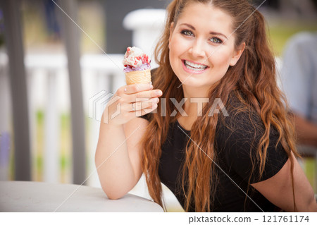 Young woman eating ice cream Young woman eating ice cream 121761174