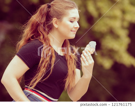 Young woman eating ice cream 121761175