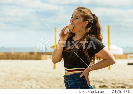 Young woman eating ice cream Young woman eating ice cream 121761176