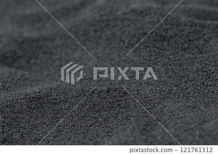 Texture of black volcanic sand on the Hawaii ocean beach. 121761312