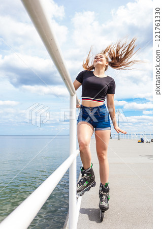 Joyful teen girl wearing roller skates Joyful teen girl wearing roller skates 121761330
