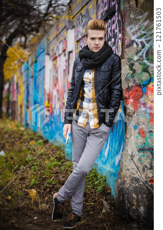 Fashion man holds mobile phone outdoor Fashion man holds mobile phone outdoor 121761503