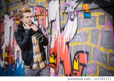 Fashion male portrait on graffiti wall 121761511
